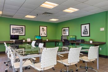 a conference room with green walls and a glass table with chairs